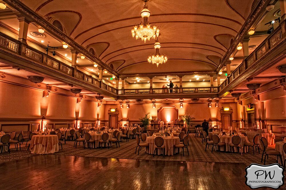 Grand ballroom bathed in golden light. Historical venue with grand and gold chandeliers