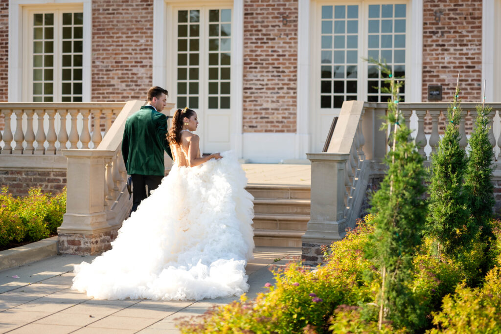 Virginia Beach wedding photographer creates candid moments with Bride and Groom walking up the stairs to enter their venue just after the ceremony
