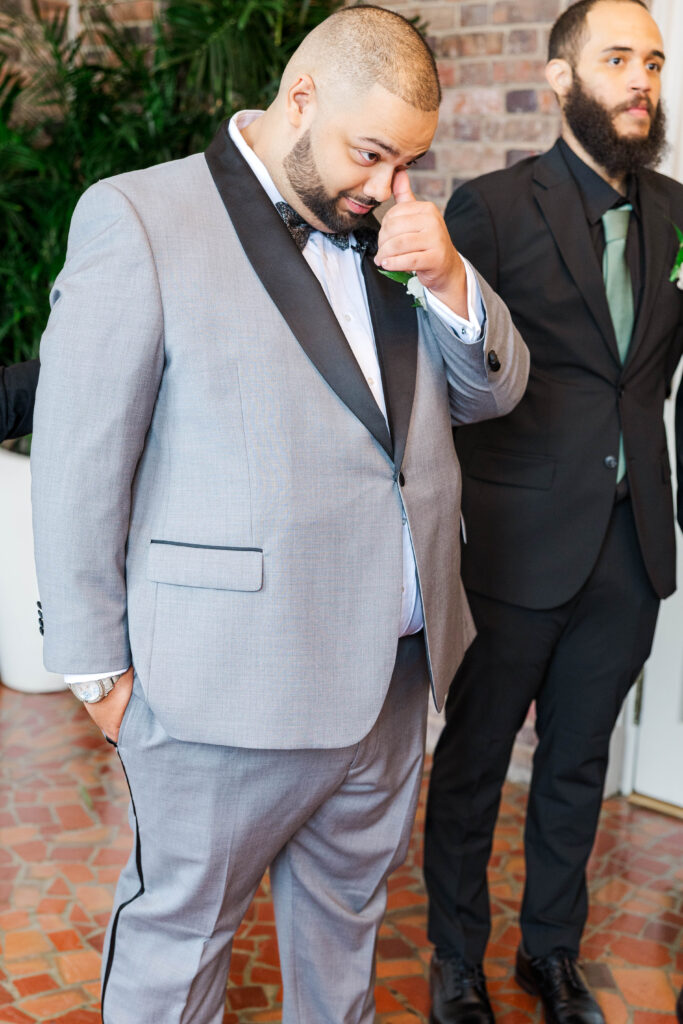 Emotional moment as the groom wipes away a tear, surrounded by his groomsmen, before the ceremony at The Virginia Cavalier.