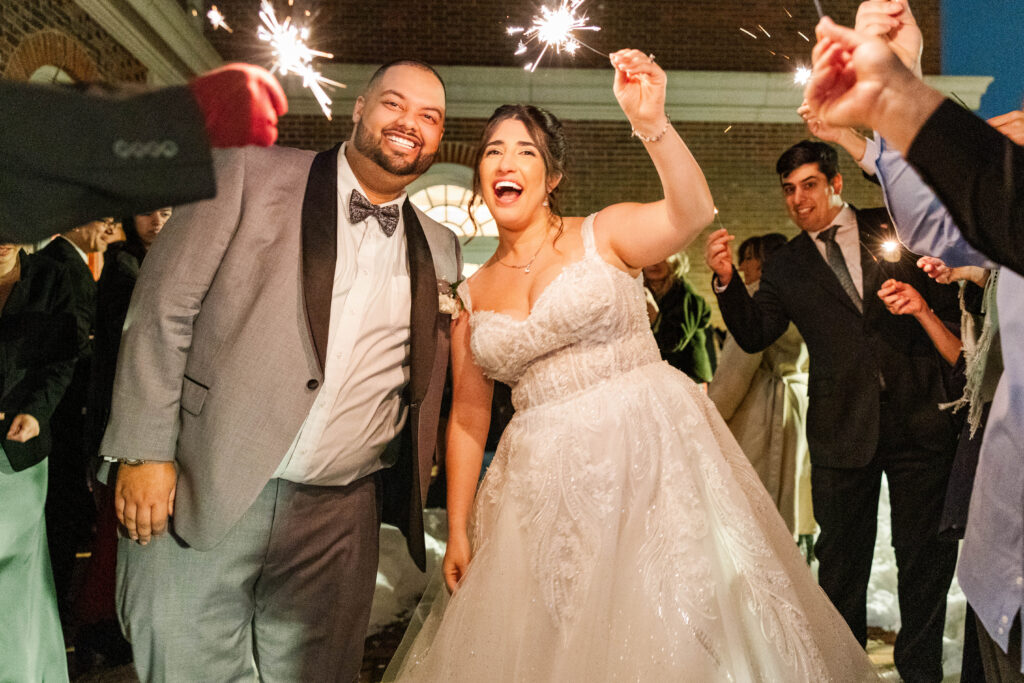 Sparker exit of the Bride and Groom among a snow covered walkway at The Virginia Cavalier.