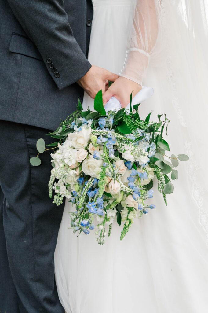 bridal bouquet of cool crisp blues and whites being held by both the bride and groom